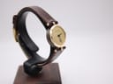 Another angled view of the Gucci 2000L watch, showing the elegant profile of the gold case and the texture of the strap.