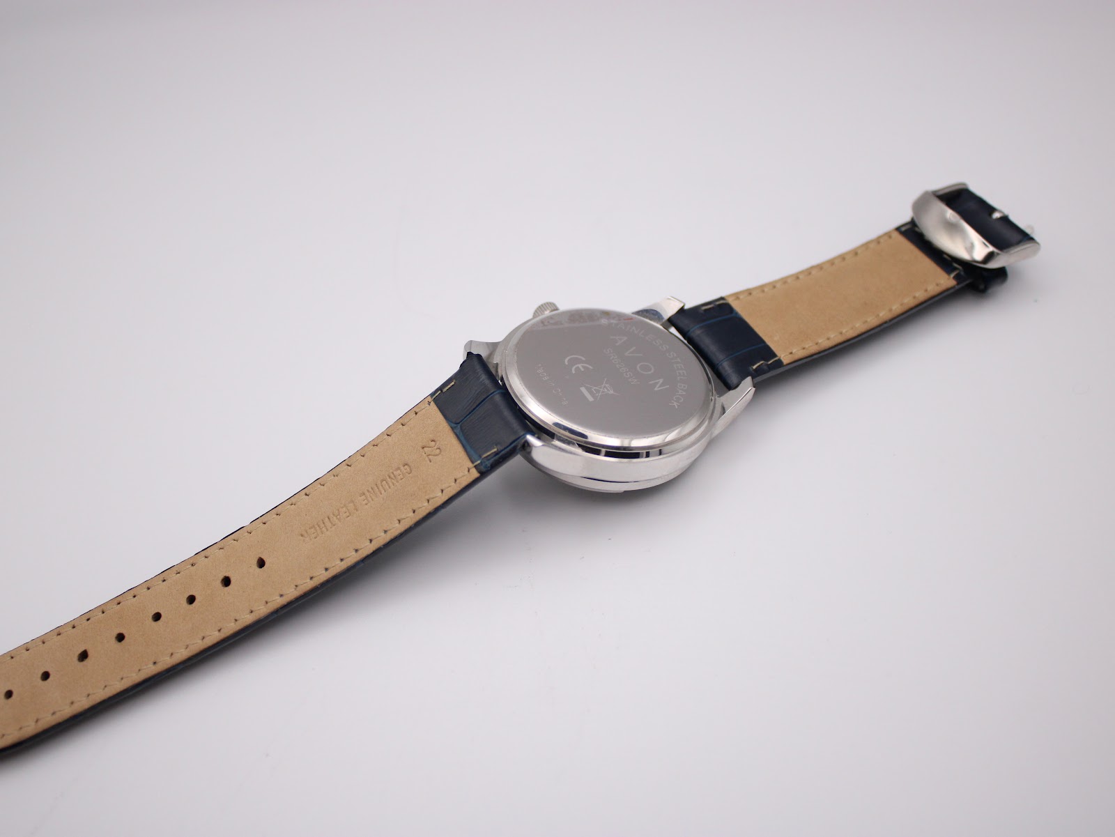 Back view of the Avon watch with the navy blue leather strap fully extended, showing the case back and the lighter underside of the strap.