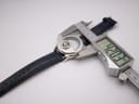 Digital caliper measuring the case diameter of the Avon watch, displaying 42.03mm, with the blue leather strap visible.