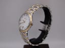 Side view of the Maurice Lacroix watch on a stand, showing the two-tone bracelet and gold-plated bezel.