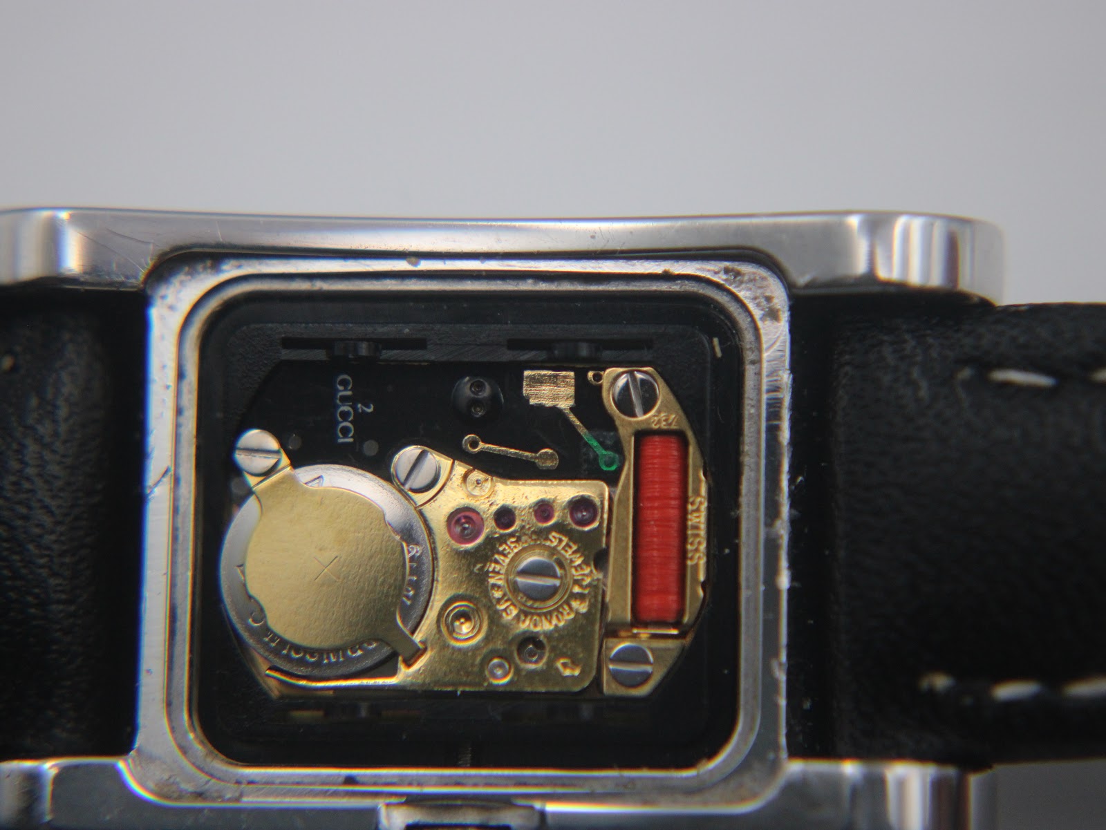 Close-up view of the Gucci 2300L quartz movement, showing the battery and internal components.