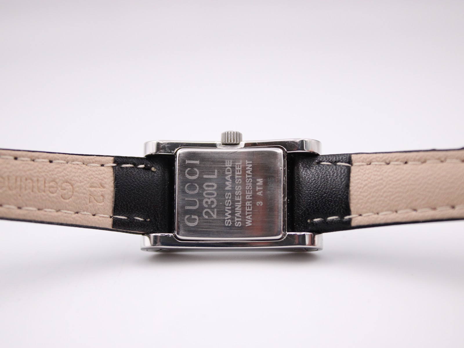Rear view of the Gucci 2300L case back, engraved with model number, 'swiss made', 'stainless steel', and 'water resistant 3 atm'.