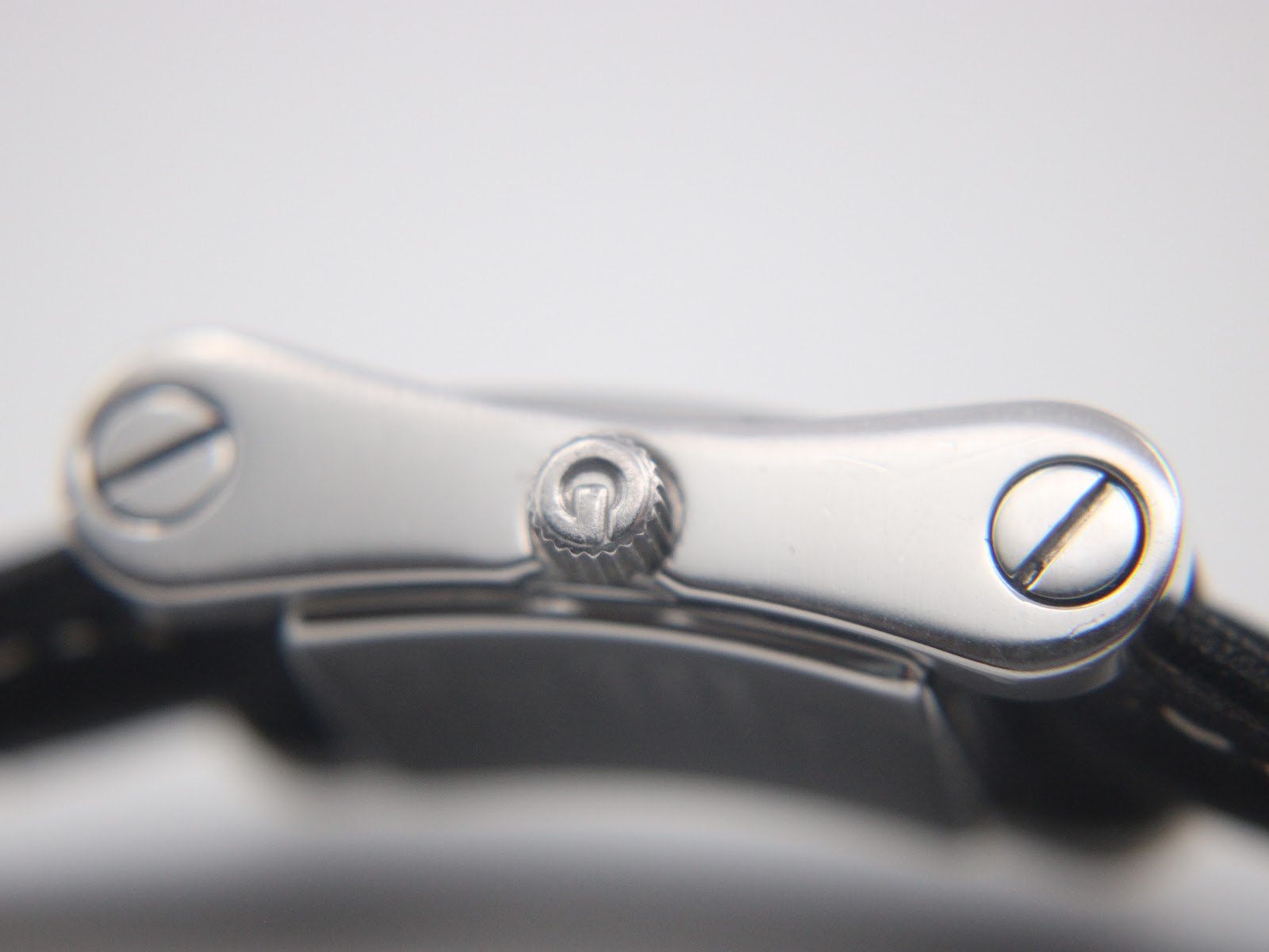 Close-up side view of the Gucci 2300L crown with the Gucci logo, and the screws securing the strap.