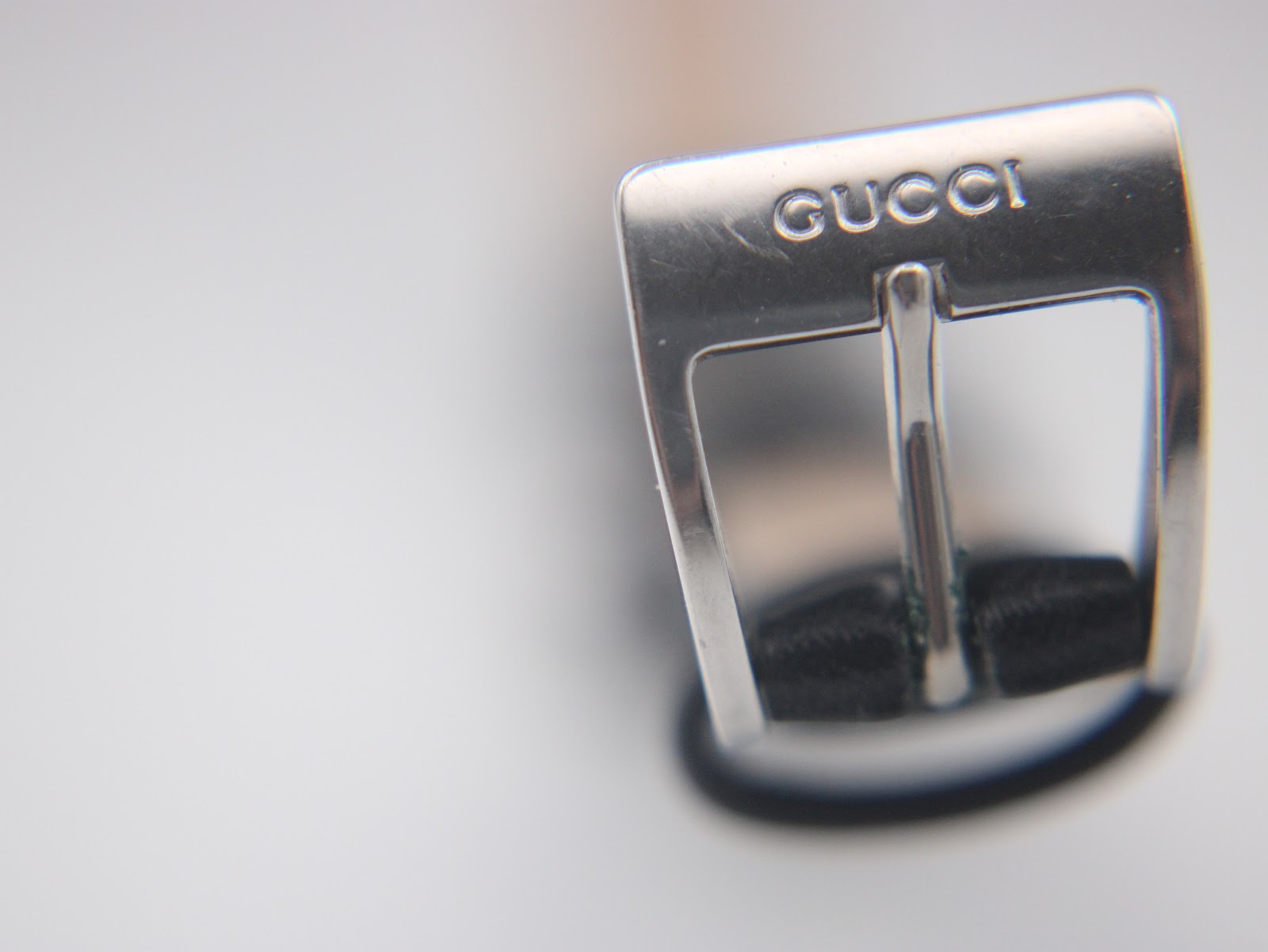 Close-up of the silver buckle for the Gucci 2300L, clearly showing the engraved 'GUCCI' logo.