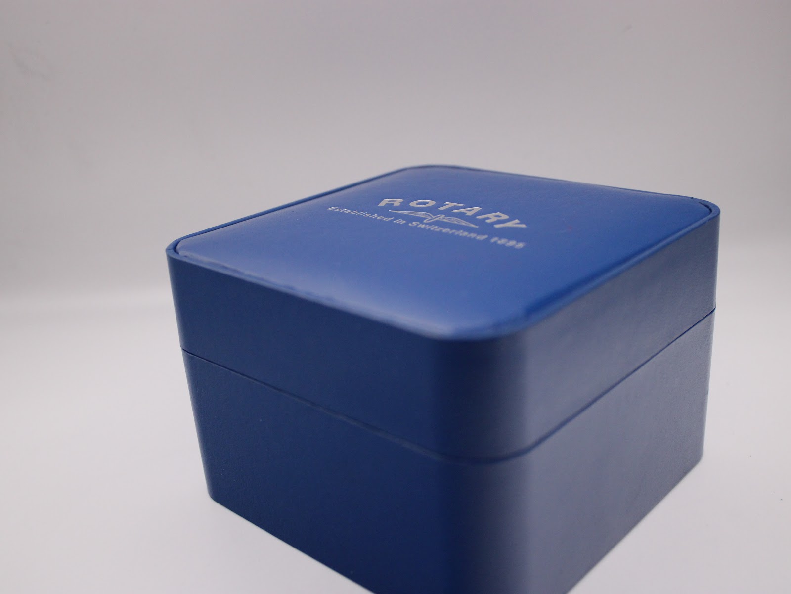 Top view of the closed original blue Rotary presentation box with the "Rotary Established in Switzerland 1895" logo embossed.