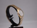 Another side-angle view of the gold plated Rotary watch on a black display stand, highlighting the bracelet links.