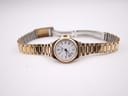 Top-down view of the gold plated Rotary watch with its bracelet unfolded, laid flat on a white background.