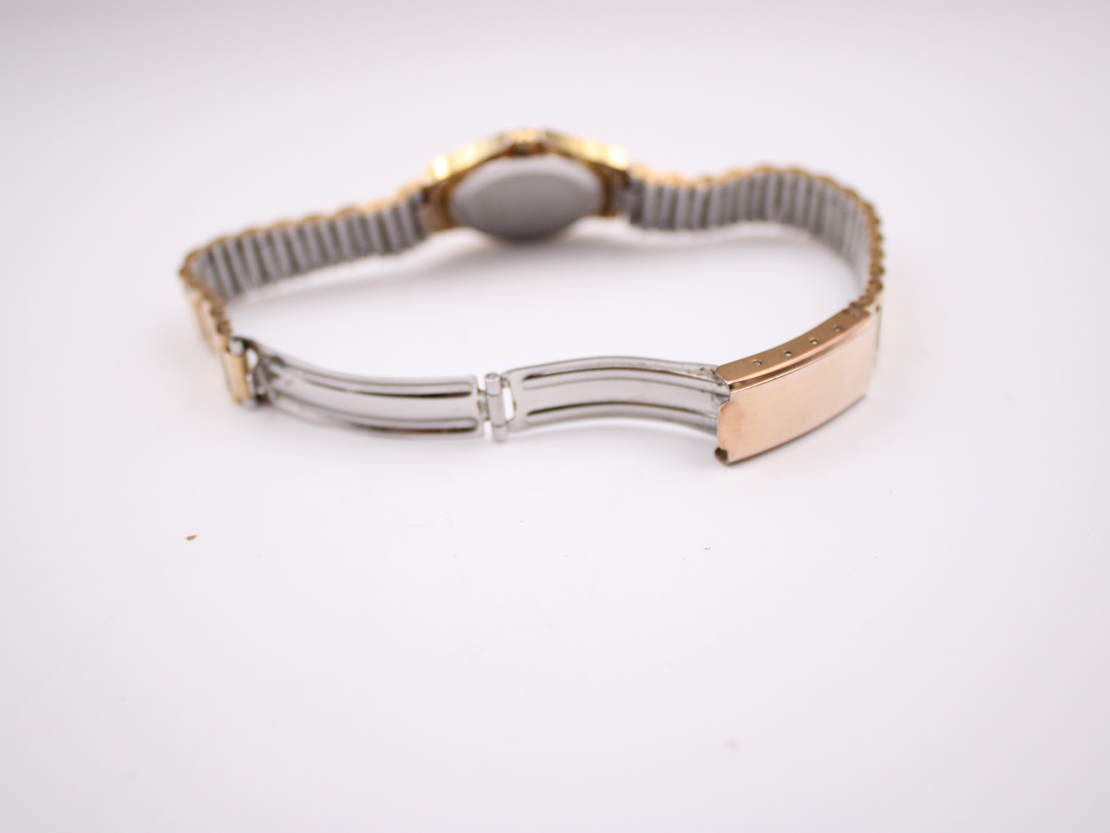 Close-up of the open gold-plated jewellery clasp on the watch's link bracelet.