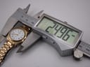 Digital caliper measuring the watch case diameter, displaying an exact measurement of 24.96 mm.