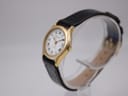 Oblique front-right view of the Tissot Stylist on a clear stand, showing gold case and black leather strap