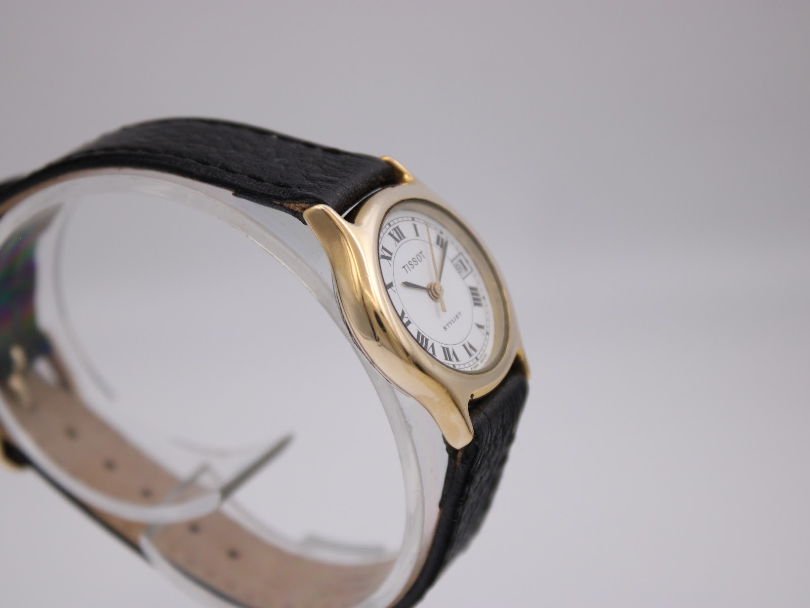 Side view of the Tissot Stylist, showing the slim profile of the gold-plated case and crown