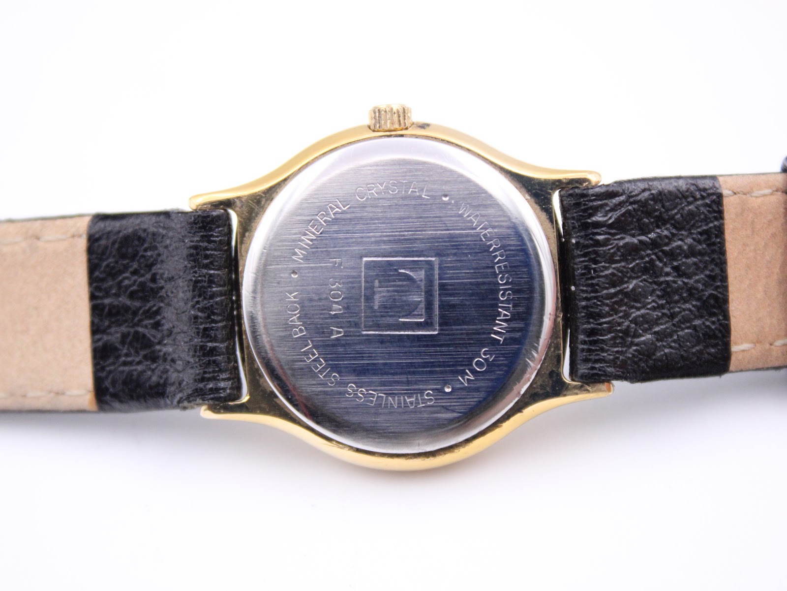 Close-up of the stainless steel case back with Tissot 'T' logo, reference F 304 A, and water resistance marking