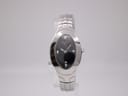 Front view of Tissot L720 ladies watch on a clear stand, showing oval black dial and stainless steel bracelet.