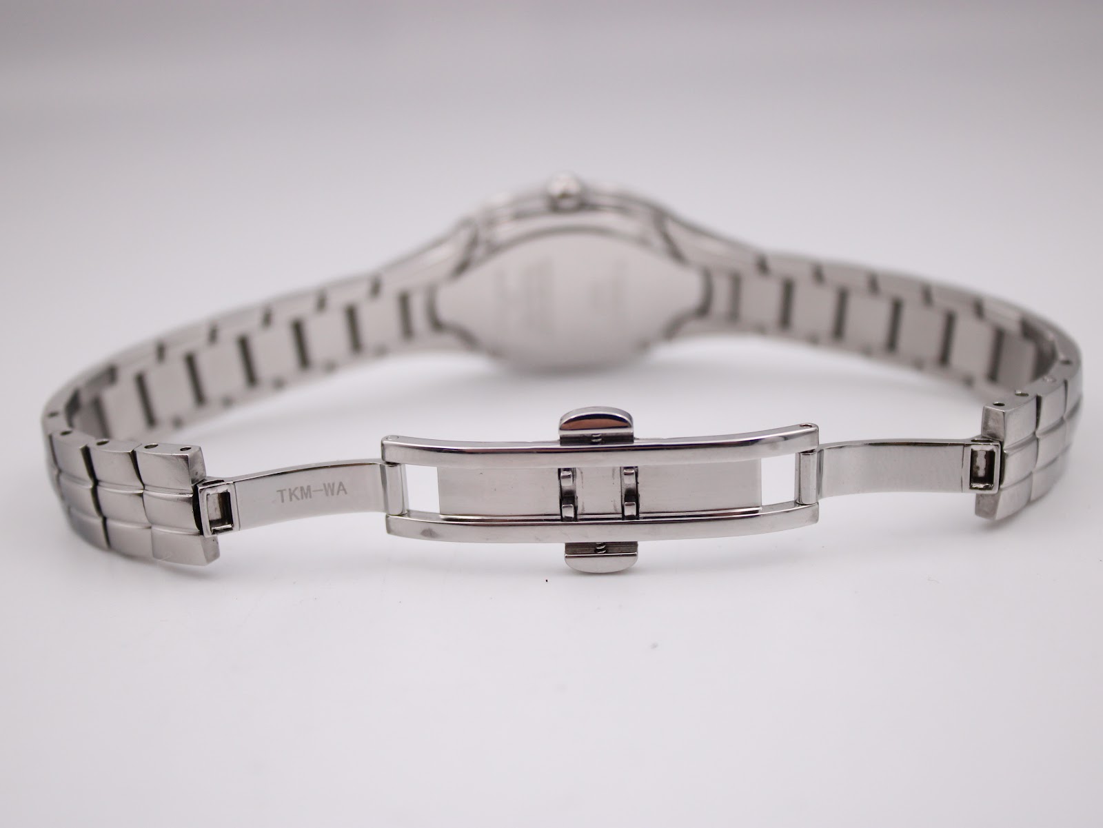 View of the open butterfly deployant clasp on the Tissot L720's stainless steel bracelet, showing "TKM-WA" marking.