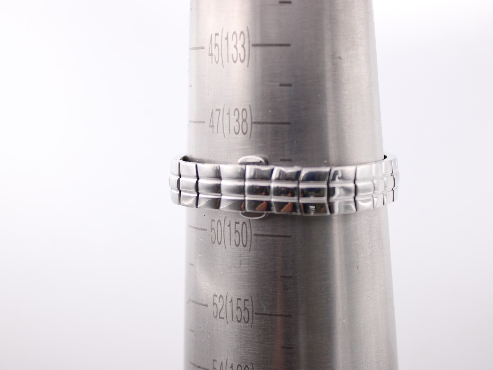 Close-up of the stainless steel bracelet wrapped around a wrist sizing cone, showing a measurement between 49 and 50 (approximately 14.5cm - 14.8cm).