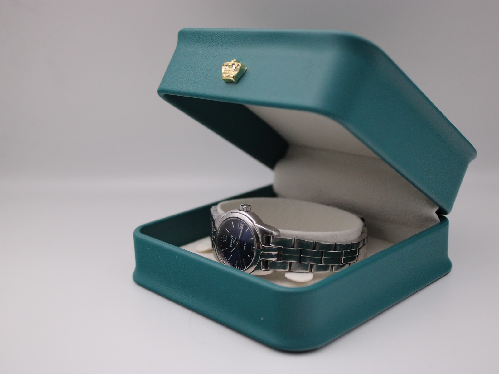 The Tissot PR 50 watch resting inside a green Tissot presentation box with a cream interior.