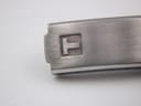 Macro shot of the Tissot 'T' logo stamped into the brushed finish of the stainless steel folding clasp.