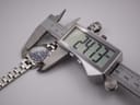 Digital caliper measuring the case diameter of the Tissot PR 50 watch, showing a precise reading of 24.73mm.