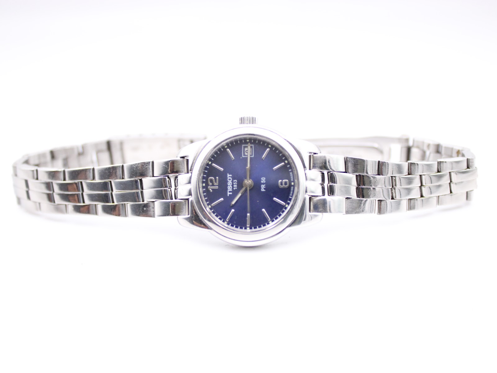 Full front view of the Tissot PR 50 watch with its stainless steel bracelet extended flat.