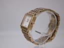 Side view of the Tissot L910 watch on a clear stand, showing the integrated gold-tone bracelet.