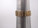 Gold-tone brick-link bracelet of the Tissot watch wrapped around a wrist sizing cone, showing wrist size markings.