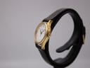 Right side view of the Tissot Seastar on a watch stand, showing the gold crown and case profile.