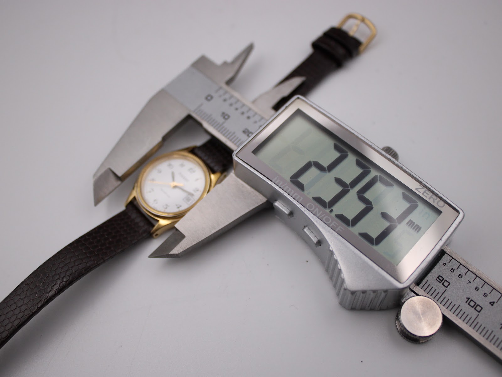 Digital caliper measuring the case diameter of the Tissot Seastar, showing a precise reading of 23.57mm.