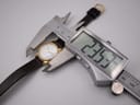 Digital caliper measuring the case diameter of the Tissot Seastar, showing a precise reading of 23.57mm.
