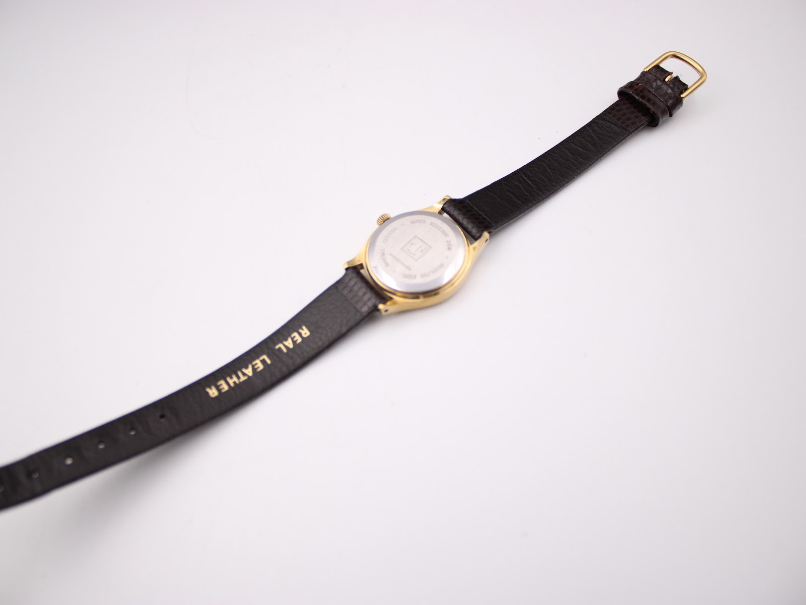 Back view of the Tissot Seastar watch laid flat, showing the 'REAL LEATHER' stamp on the strap.