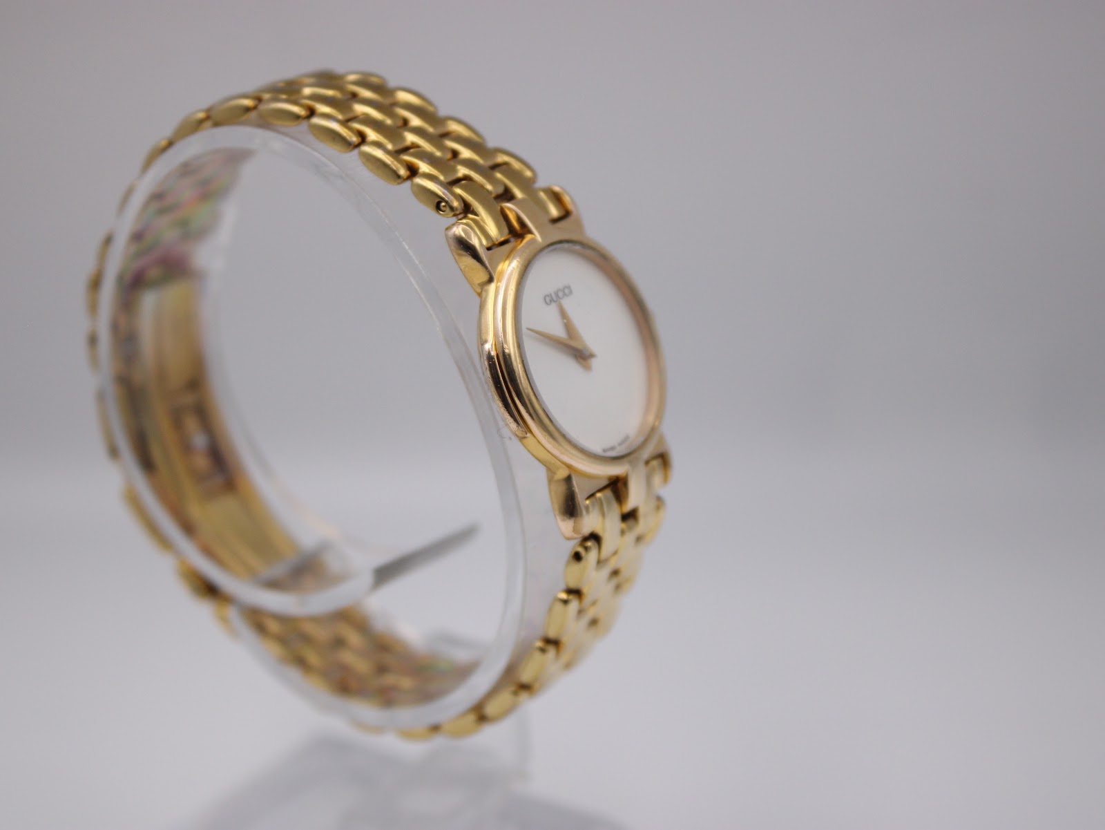 Another angled side view of the Gucci 3400L watch, highlighting the gold-tone multi-link bracelet and the minimalist dial.