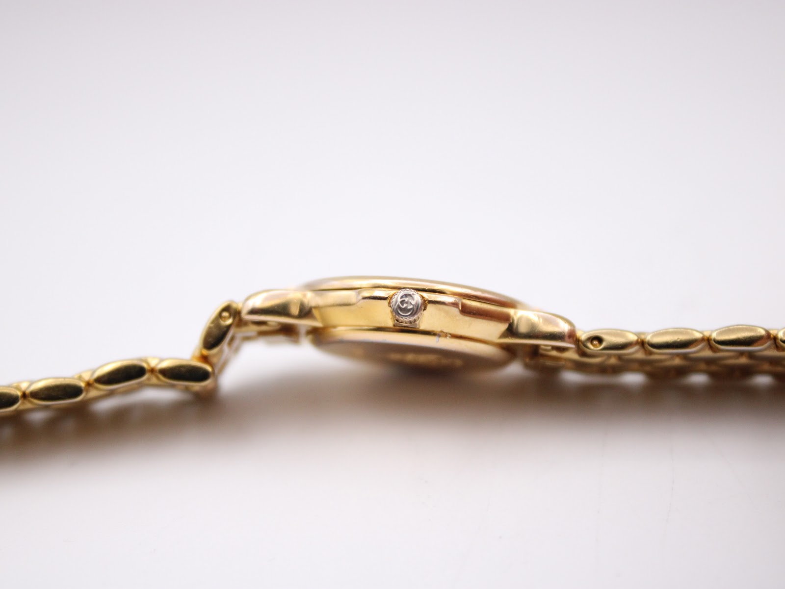 Side profile of the Gucci 3400L watch, featuring the original signed crown with the 'G' logo.