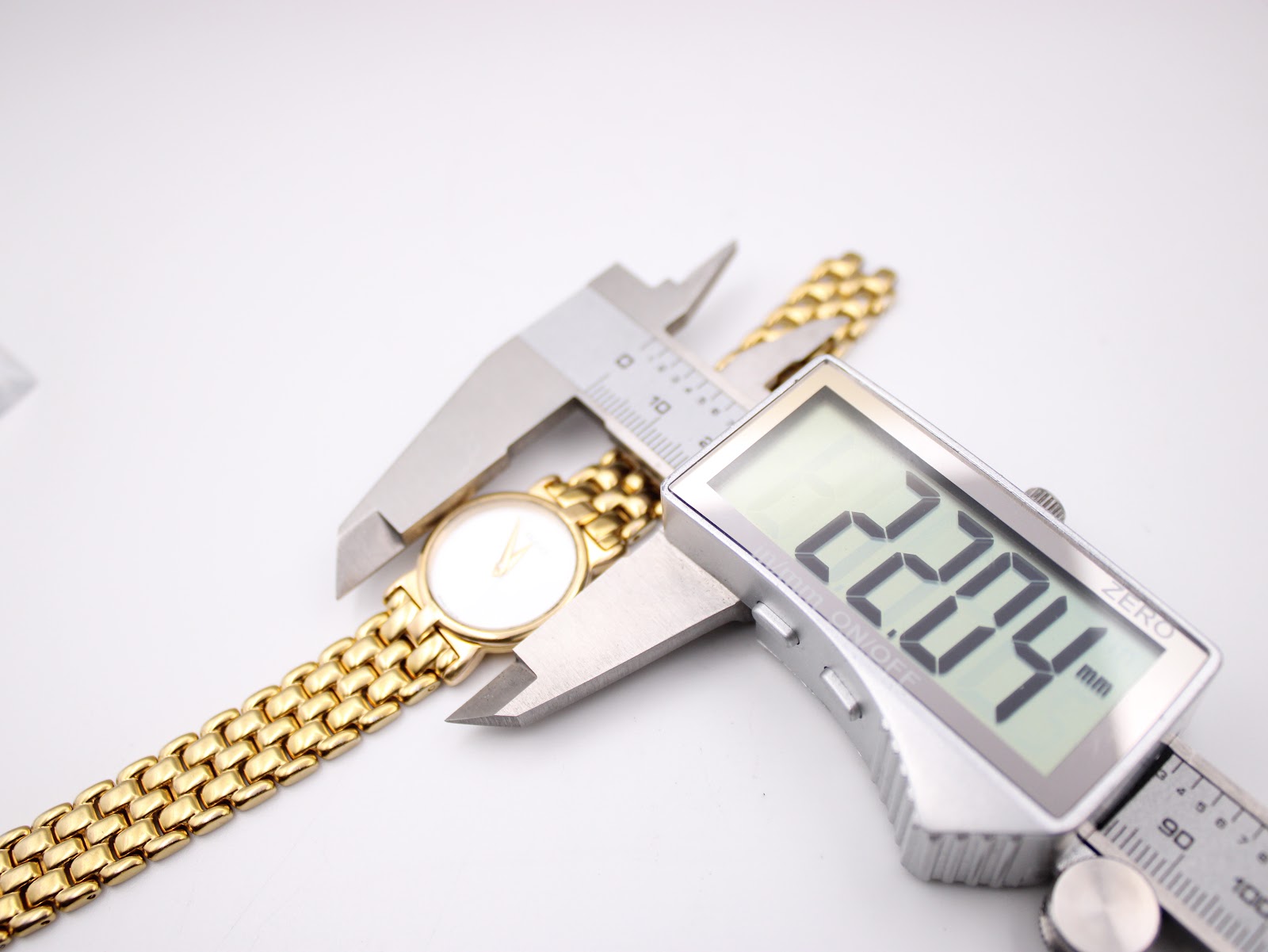 A digital caliper measuring the case diameter of the Gucci 3400L watch, displaying a precise measurement of 22.04mm.