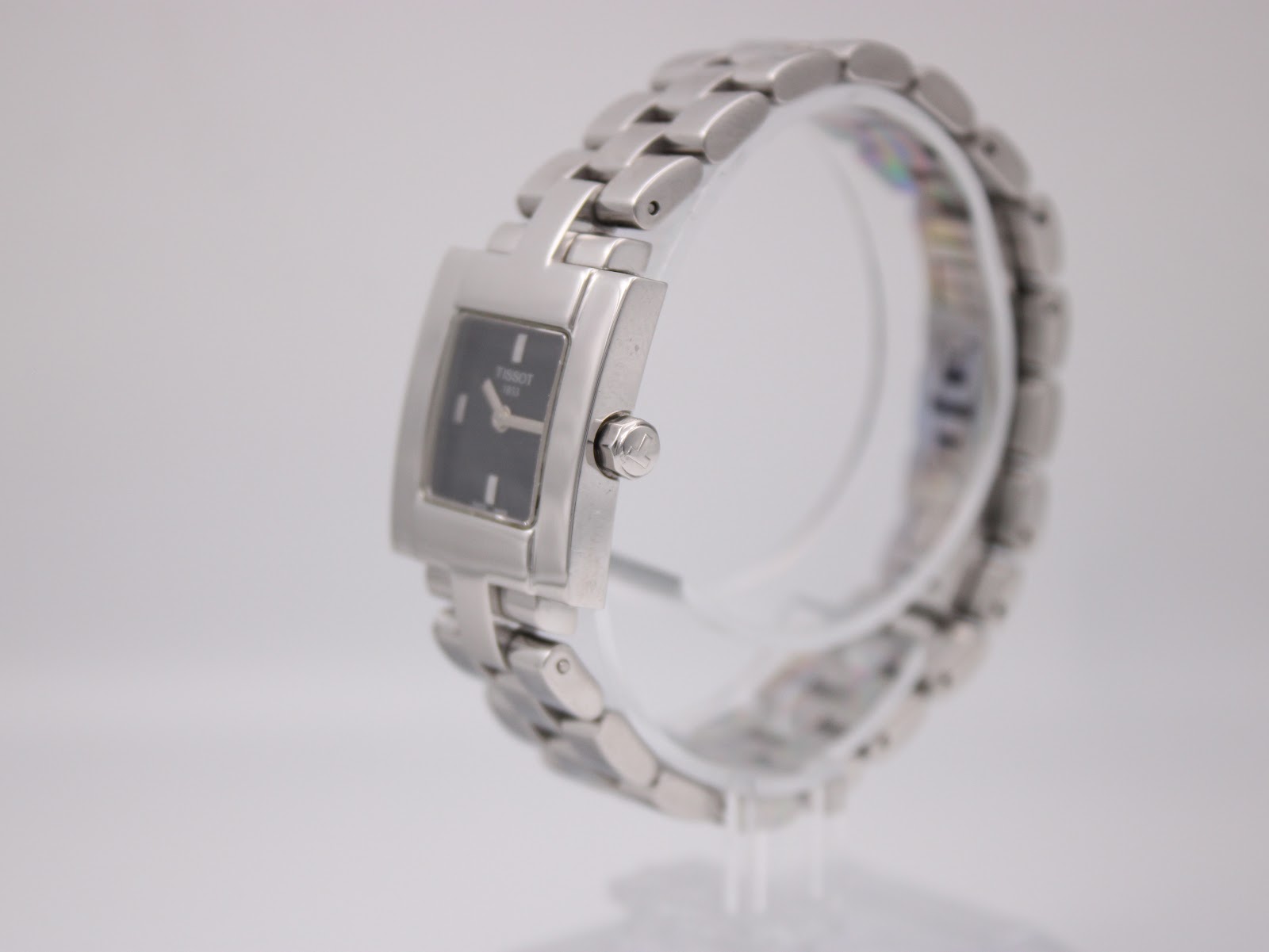 Right-side view of the Tissot T-Trend watch on a clear display stand, showing the polished stainless steel case and crown.