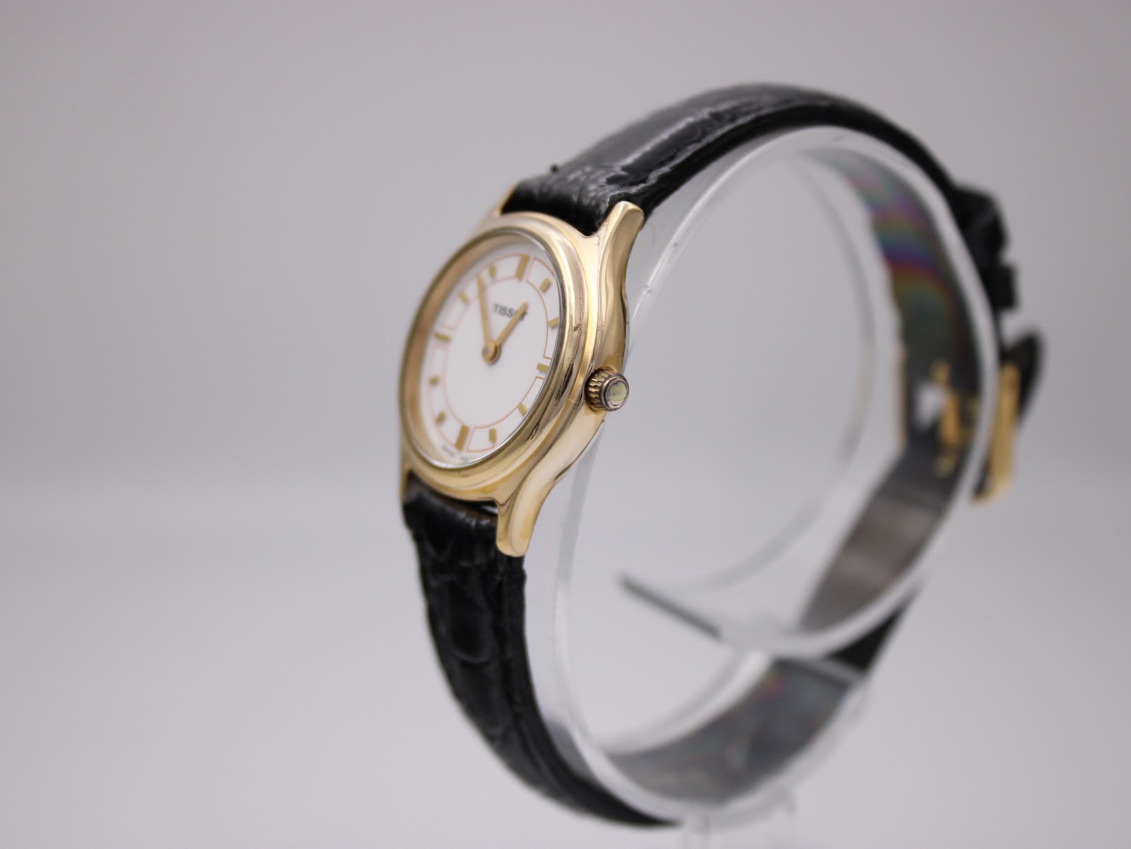 Angled side view of the Tissot F300 watch, showing the gold plated case and crown.