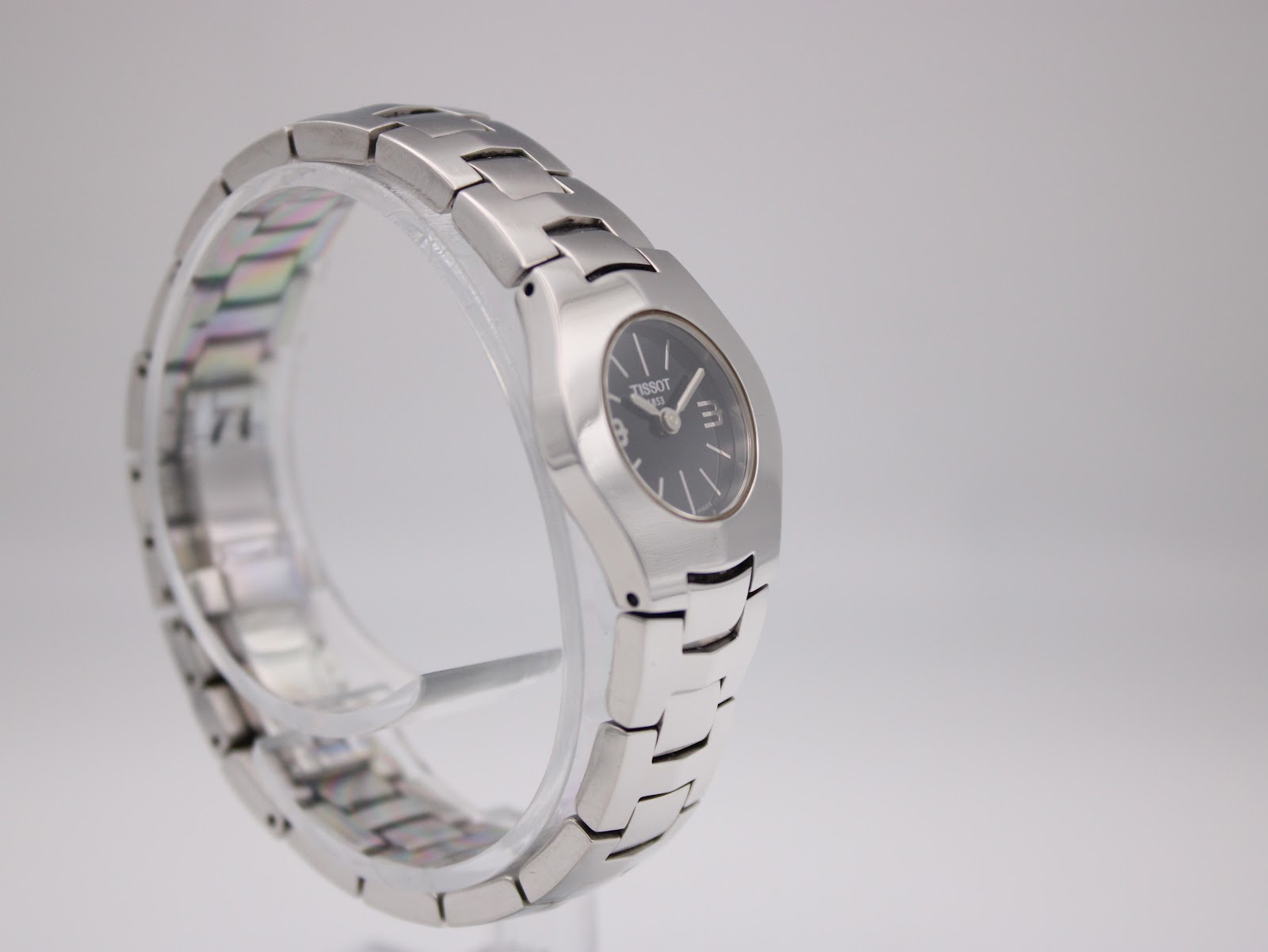 Another angled view of the Tissot T-Trend watch on a clear display stand, highlighting the bracelet design.