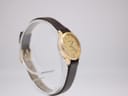 Another angled side view of the Tissot watch on a stand, showcasing the dial and case details.