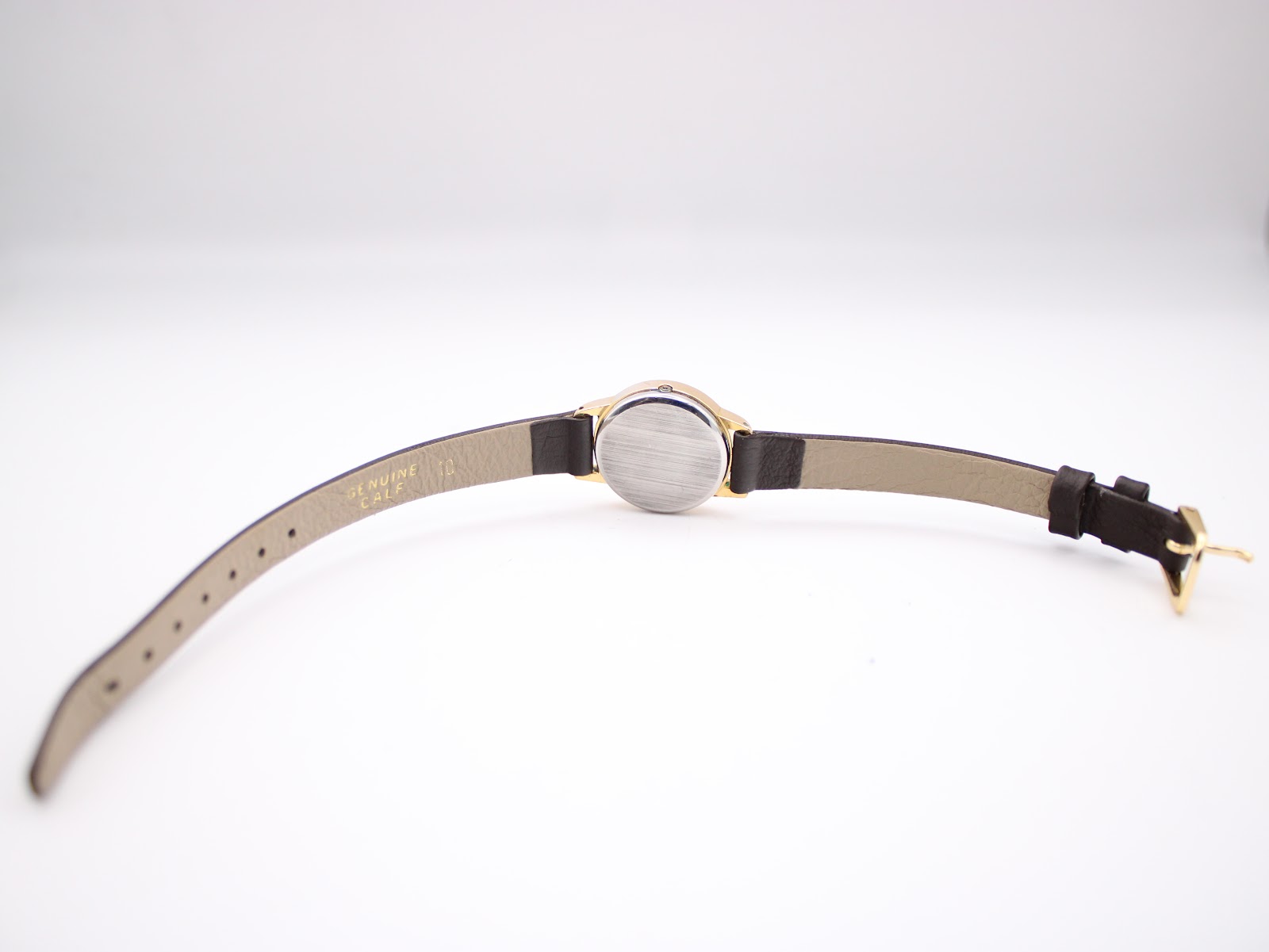 Back view of the Tissot watch showing the stainless steel case back and the full dark brown leather strap.