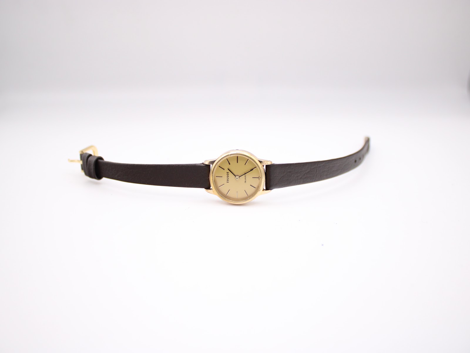 Top-down view of the Tissot watch laid flat, highlighting the long dark brown leather strap.