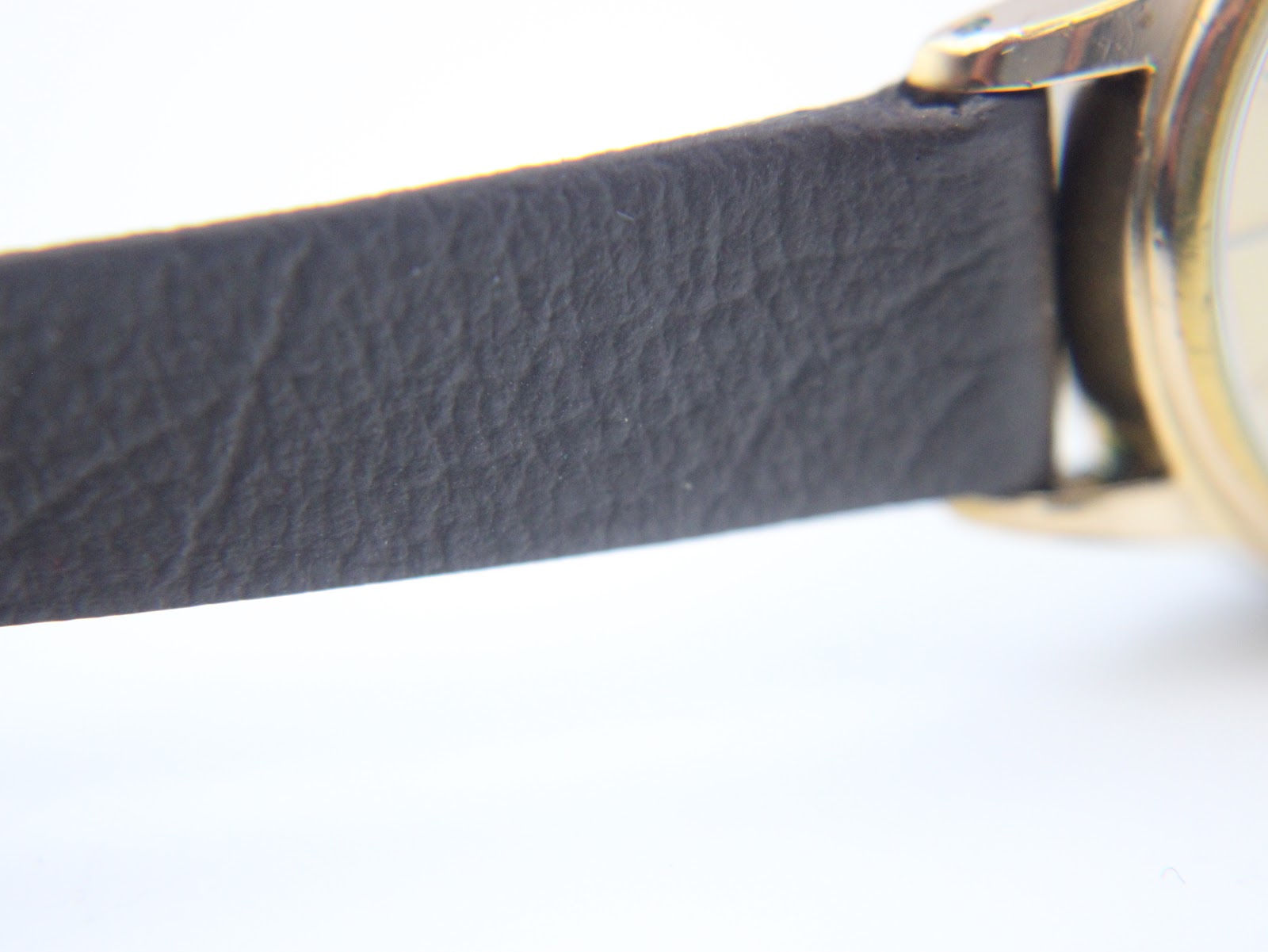 Close-up of the textured dark brown genuine calf leather strap.