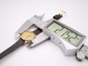 Overhead view of a digital caliper measuring the Tissot watch case diameter at 21.62mm.