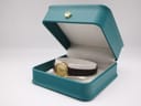 Tissot watch presented open in a teal watch box with a gold crown emblem.