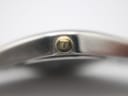 Macro shot of the gold-tone crown, clearly showing the embossed Tissot 'T' logo.