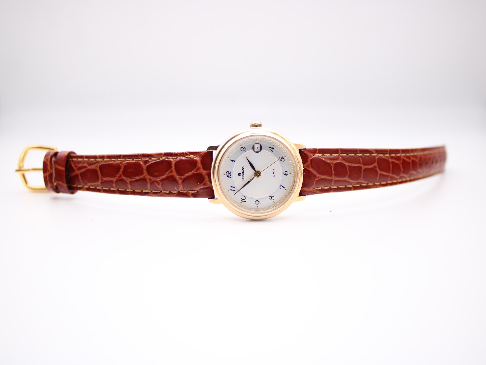 Full length view of the Junghans watch with its brown crocodile grain leather strap and gold-tone buckle, against a white background.
