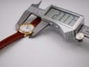 Digital caliper measuring the watch case diameter at 27.1mm.