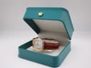 The Junghans watch nestled inside a green presentation box.