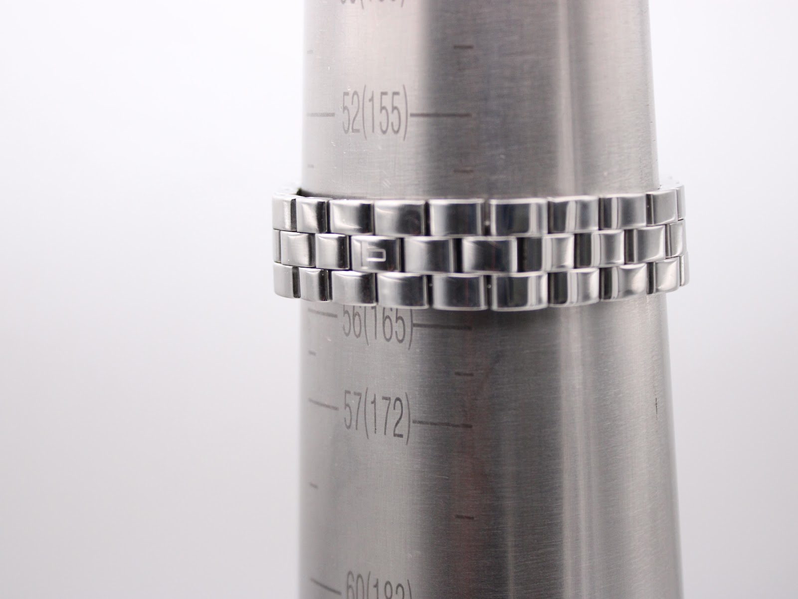 Close-up of the stainless steel bracelet on a wrist sizing gauge, indicating a wrist circumference of approximately 16.5cm (165mm).