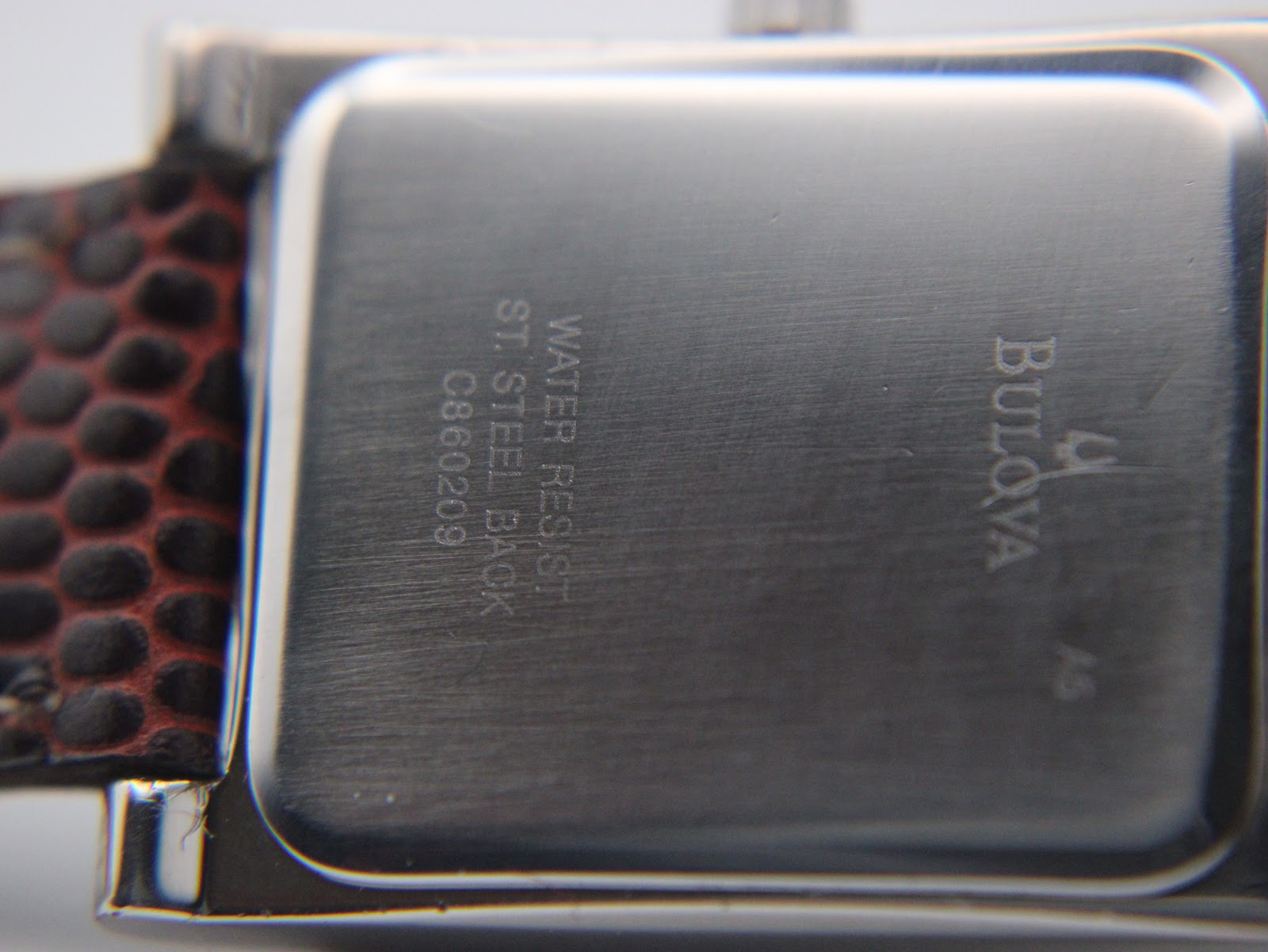 Close-up of the polished stainless steel case back, showing 'WATER RESIST ST. STEEL BACK' and model reference C860209 engraving.