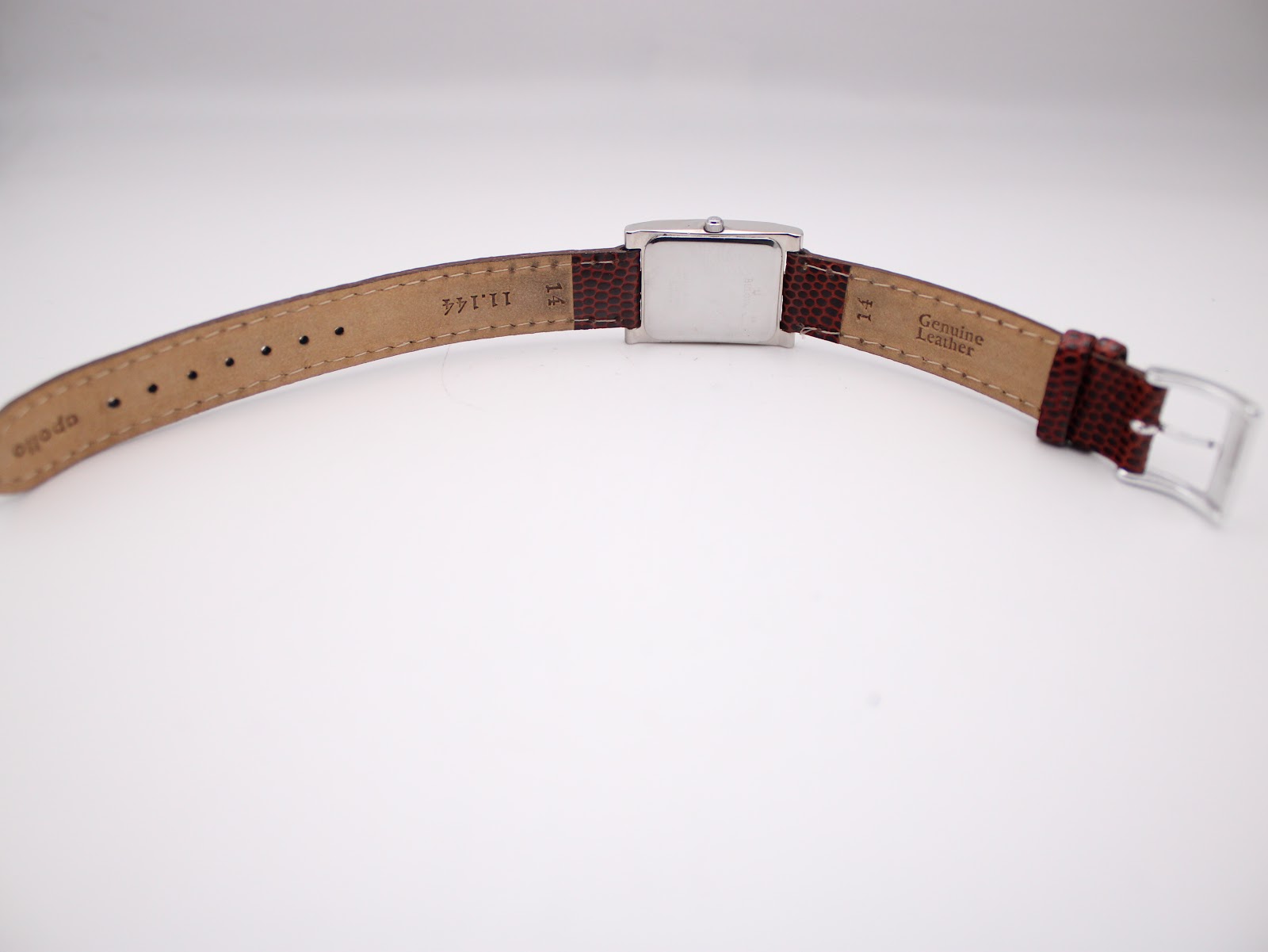 Underside of the burgundy leather strap, showing 'Genuine Leather' text and strap markings.