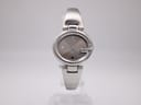Front view of the Gucci 134.5 watch with its iconic G-shaped case and silver dial on a plain background.