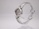 Angled side view of the Gucci 134.5 watch showcasing the integrated stainless steel bangle bracelet on a display stand.